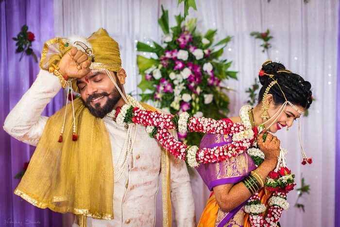 Young Indian Bride groom posing for photograph. Groom kissing the forehead  of bride. The couple is wearing traditional indian wedding dress which is  designer lehenga for bride and sherwani for groom. Stock-bilde |